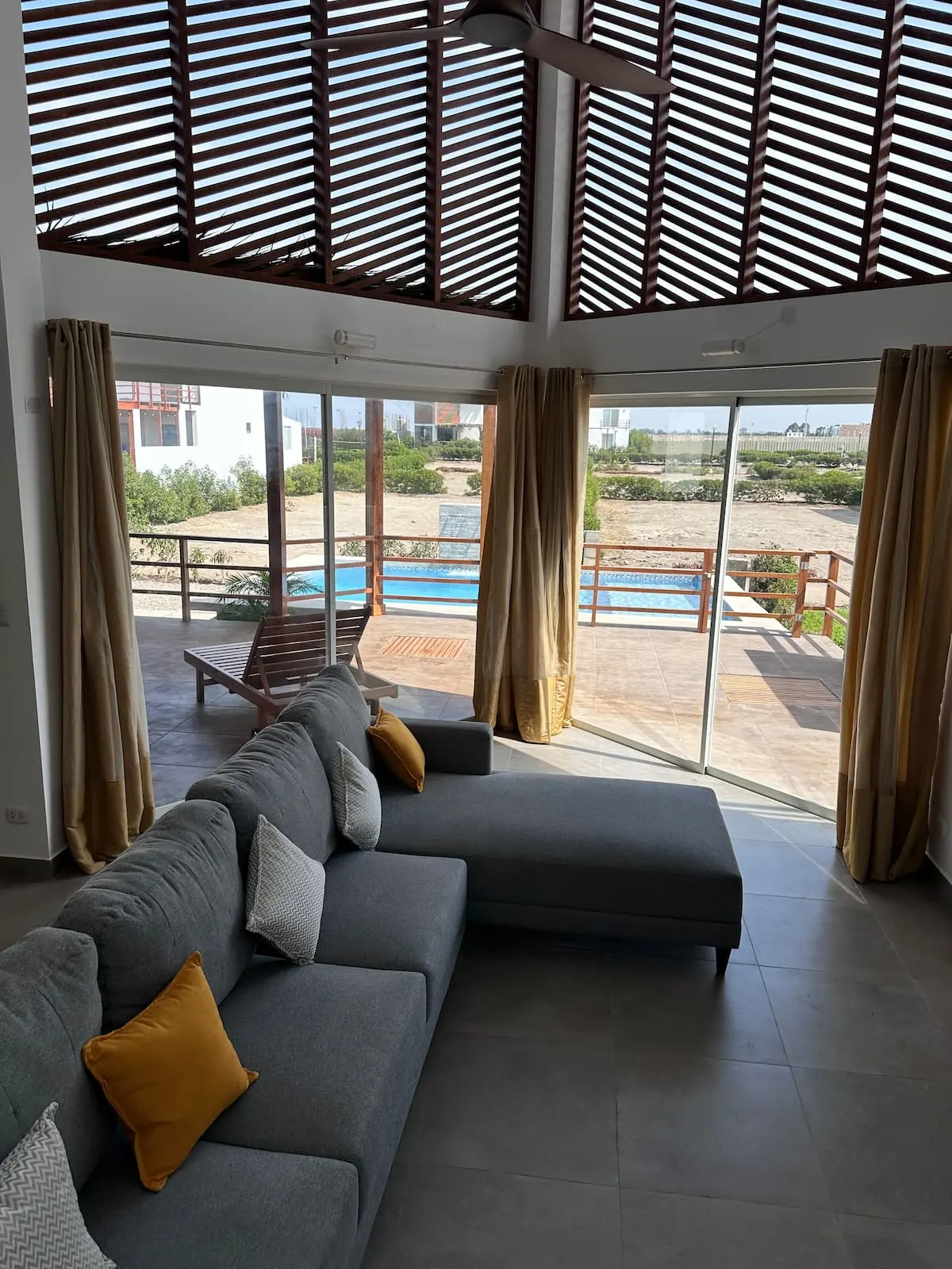Sala de doble altura con vista a la piscina