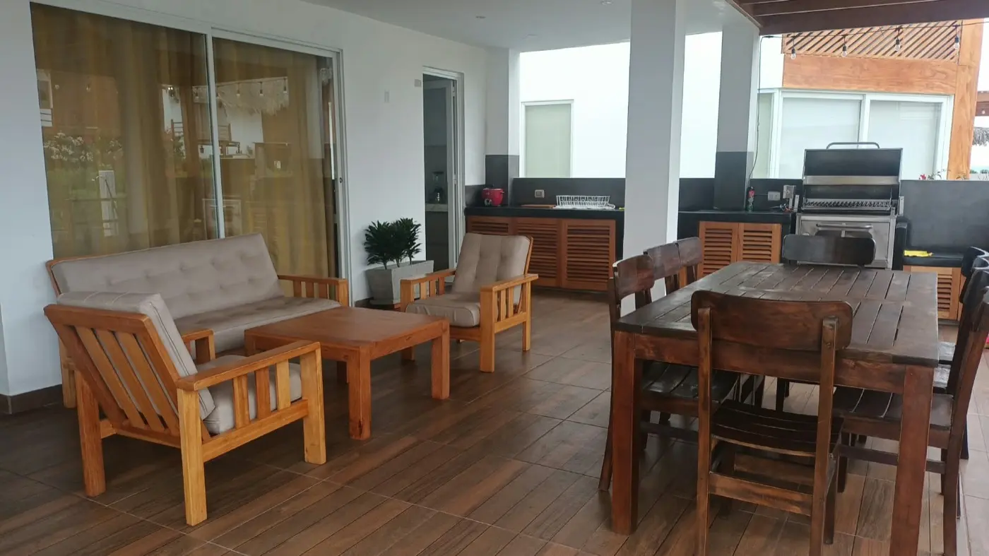 Terraza con sala, comedor de madera y parrilla